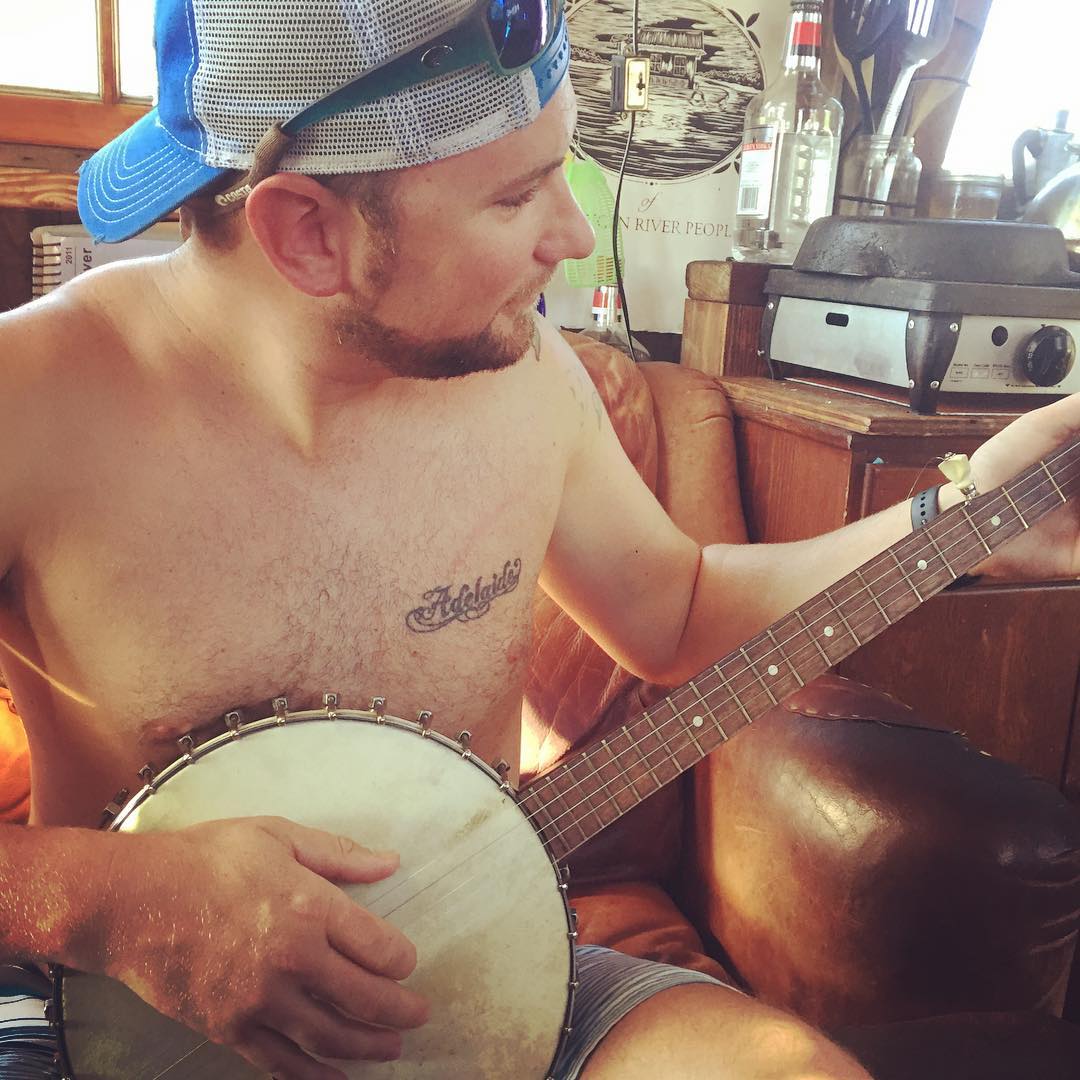 Visitor Nate playing banjo during the shantyboat open house