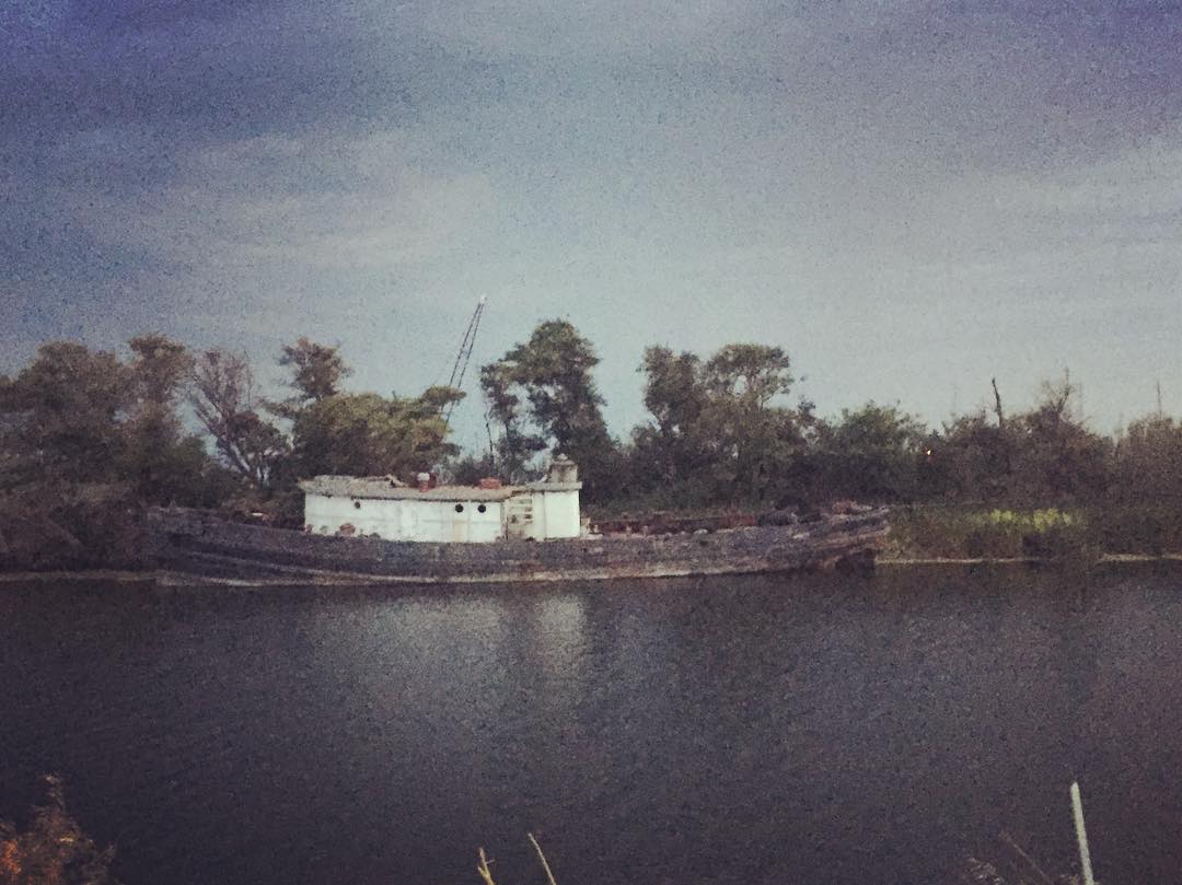 Large wreck under stormy skies on Sevenmile Slough as we drive out of the delta towing the shantyboat