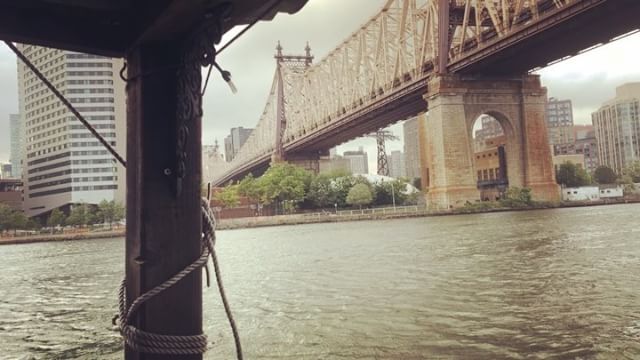 Queensboro Bridge across Roosevelt Island with the little shantyboat on the East River heading toward Brooklyn